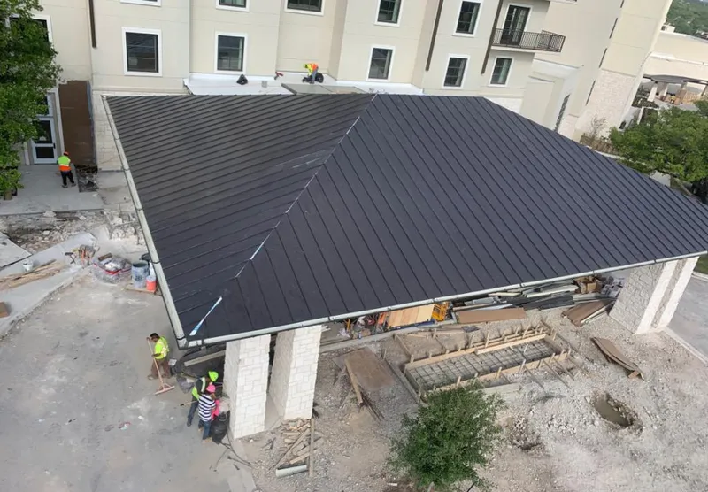 Metal roofing installation team working on a commercial building in San Carlos Park